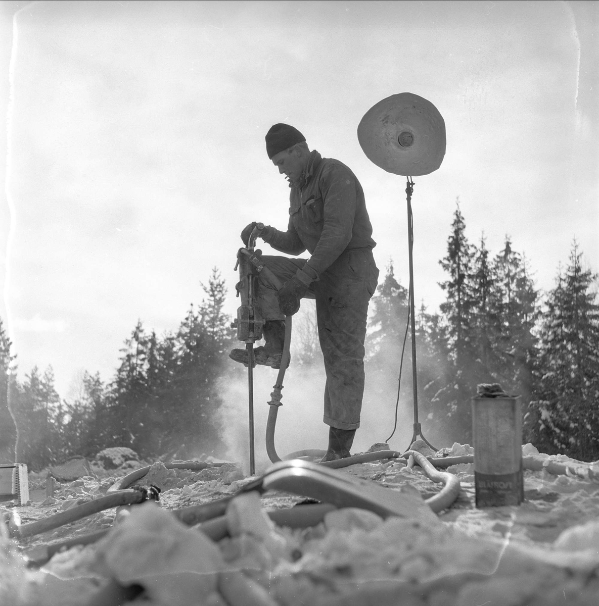 Torp flyplass, Sandefjord, 14.02.1955. Mann i arbeid med pressluftborr.
