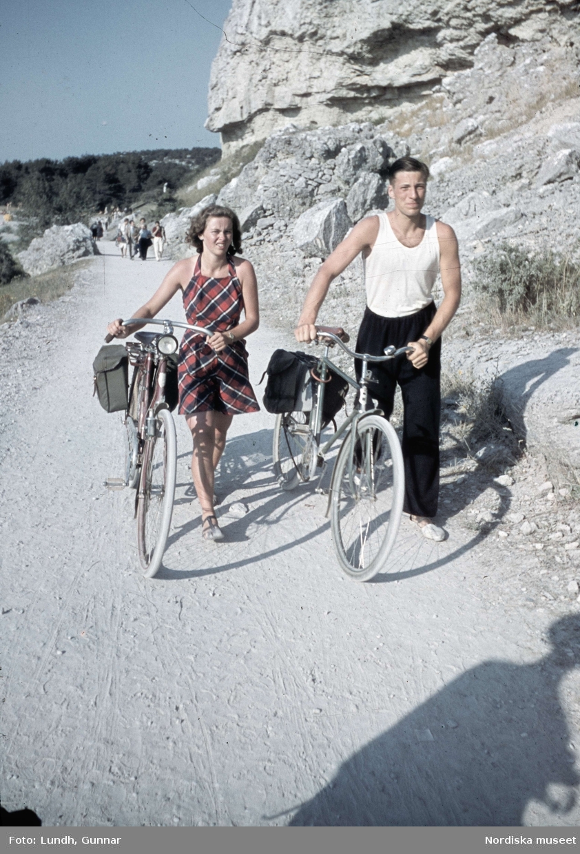 En man och en kvinna leder var sin cykel. Snäckgärdsbaden, Visby, Gotland.