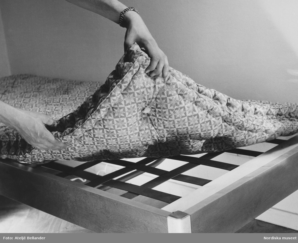 Två händer demonstrerar en madrass på säng. ”Bäddmadrass av tagel på Telaxbotten. Denna botten knarrar inte och madrasskydd behöver ej användas till den, då den är gjord av elastiska band som inte nöter madrassen.