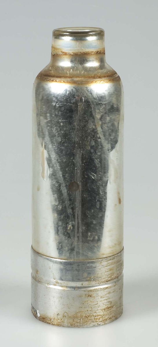 Termosflaska av glas med nederdel av metall, sannolikt aluminium. Text i relief på nederdelen: KOKHET. Hör till termos UM30924b. 