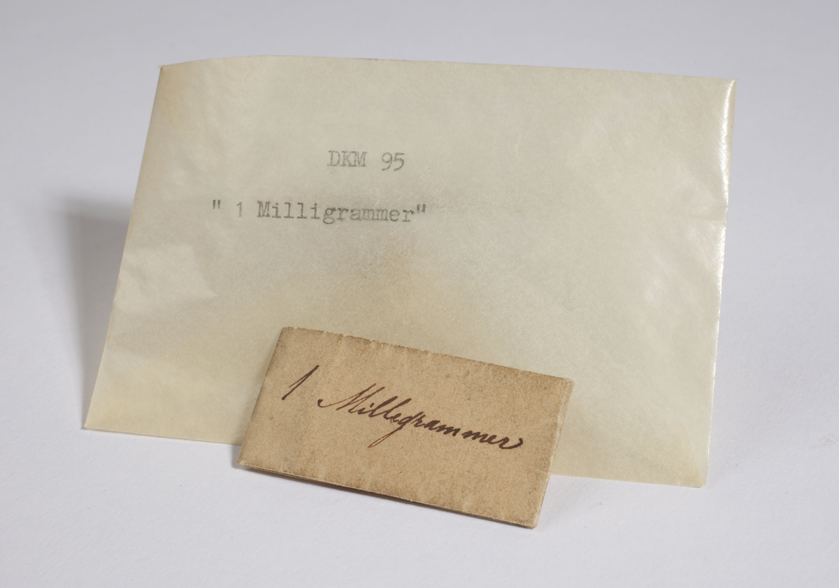 Papir brettet til en konvolutt som inneholder flere små, tynne metallbiter.