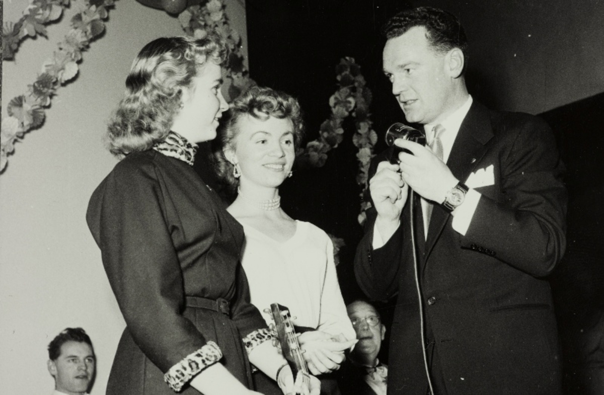 Kjellaug Lien og Hjørdis Lien, duoen "Søstrene Lien" sammen med konferansier Rolf Kirkvaag på firmafesten til Jonas Øglænd Sandnes, "Ø-festen", 19.12.1955