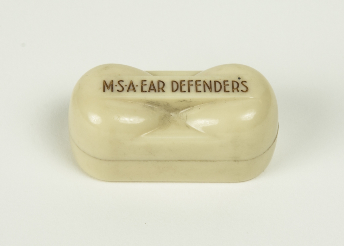 Hörselskydd typ öronproppar. Ligger i plastdosa märkt MSA EAR DEFENDERS. Gängse typen av hörselskydd innan kåporna kom.