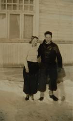 Ung kvinne og ung mann foran et hus