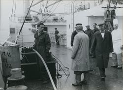 Arbeidere, menn og en kokk på dekk på cargolineren M/S Sunda