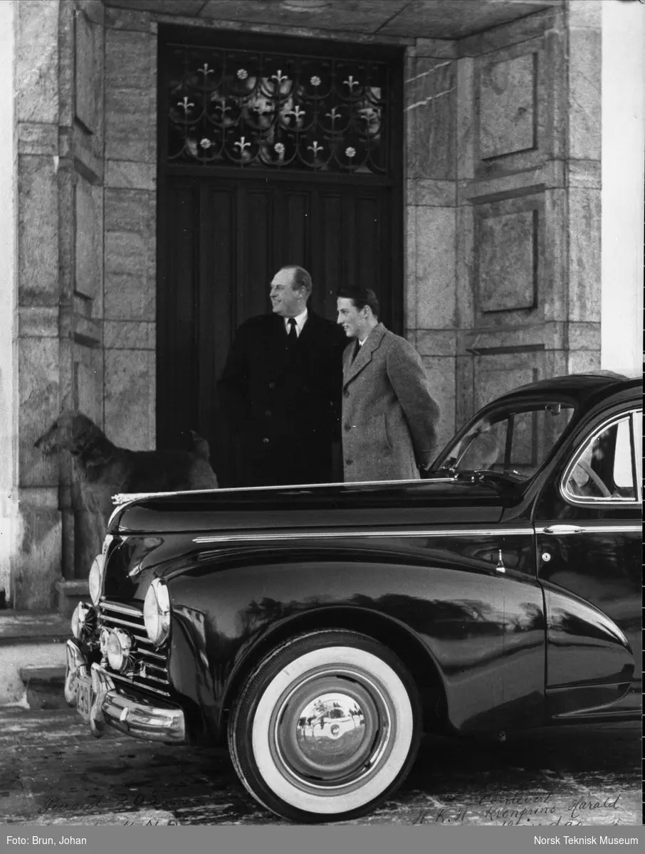 Peugeot 203 overlevert til kronprins Harald på 18-årsdagen, kong Olav står ved siden av kronprins Harald bak bilen, bilens registreringsnummer er C 2239