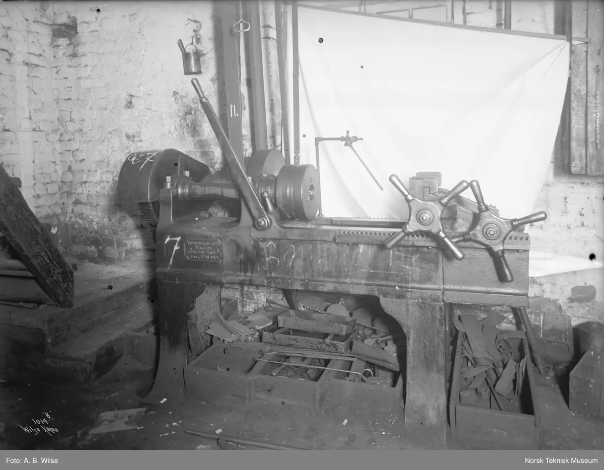 Dreiebenk trolig på Thunes Mekaniske Verksted på Skøyen i Oslo. Maskin merket med 7, bilde merket med 1014 B Wilse Xania. Emblem på maskin merket Rushworth & Co Makers, England.