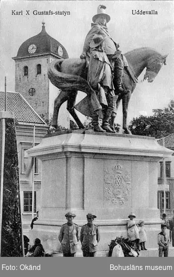 Tryckt text på vykortets framsida: "Carl X Gustafs statyn Uddevalla".
