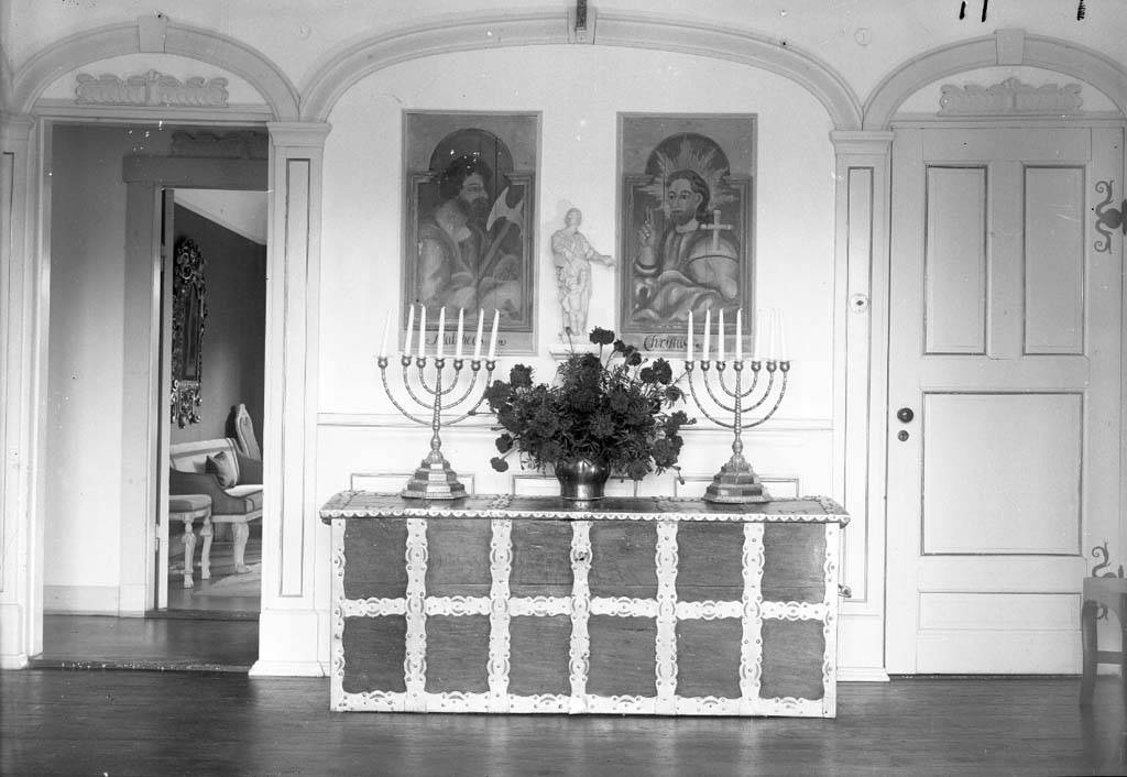 Enligt fotografen: "D. 8 sept 1934 (Övre hallen) Konsulinnnan Aspegren Stenungsön".
Uppgifter från givaren: Övre hallen, kista med två kandelabrar