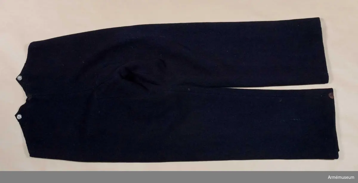 Grupp C I. 
Byxorna är av mörkblått kläde, försedda med ljusblå passpoal och fodrade med grått tuskaftat linne.