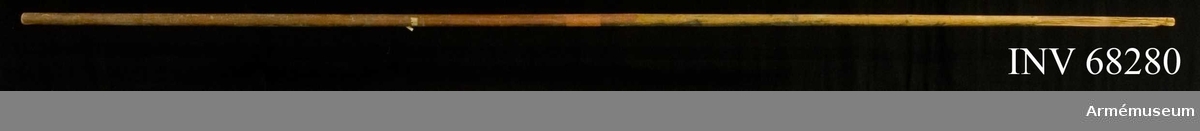 Fanstång, rundstav av furu, målad i svart och rött. Mitt på stången en mässingsögla.

Fragment av fastnitad fanduk: 1210 mm.
