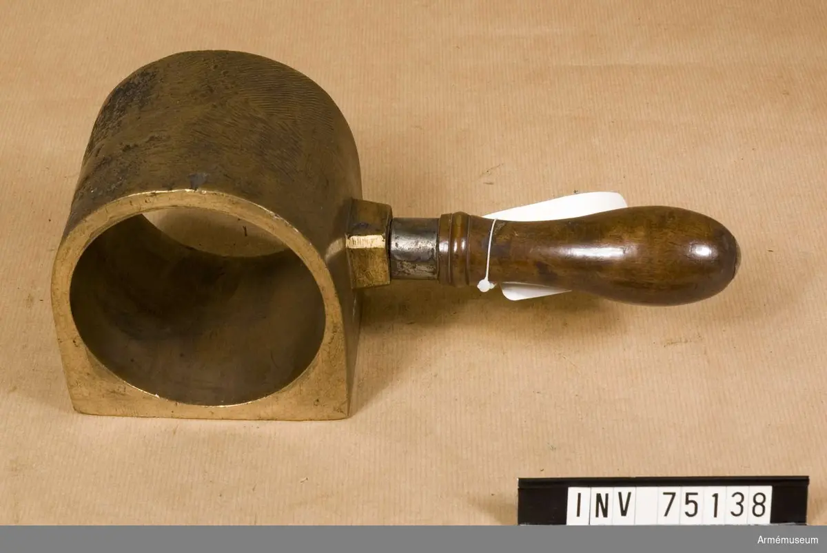 Grupp F:III(överstruken) V.
Schamplun av metall med handtag av trä för prövning av färdiga karduser eller skott av 6-pundig kaliber. 
