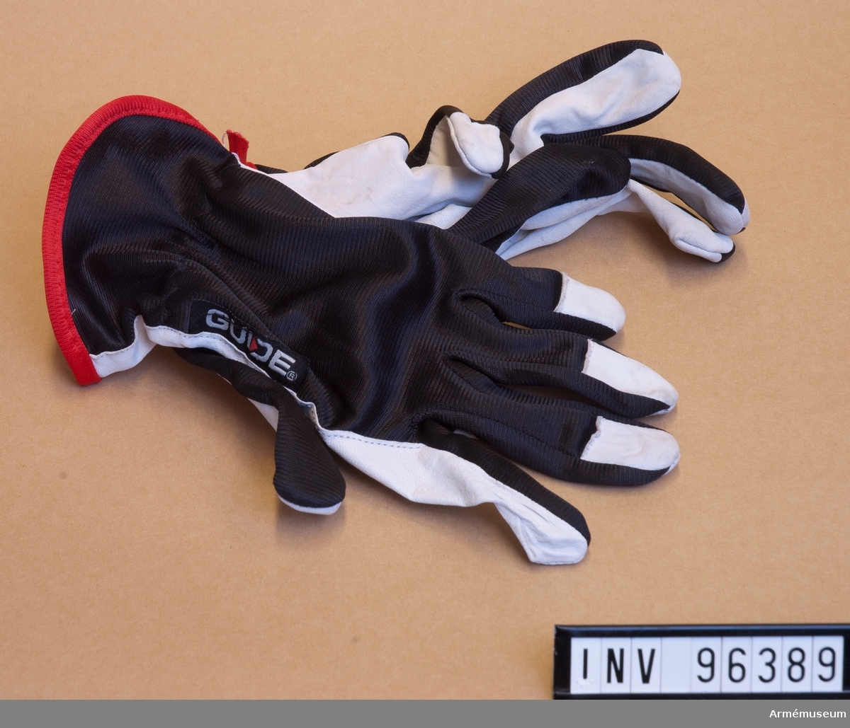 Ett par handskar i syntettyg med läderskoning.