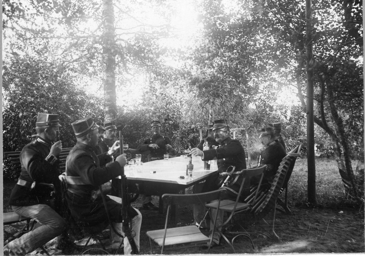 Officerare vid Älvsborgs regemente I 15 sitter runt bord på Fristad hed och dricker öl(?).