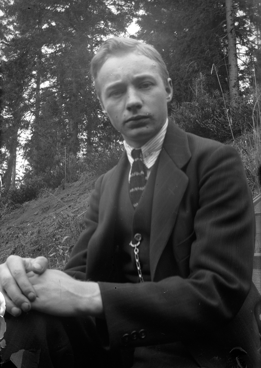 Gustav Andersson sitter i en slänt i skogen vid Lungkliniken i Eksjö.