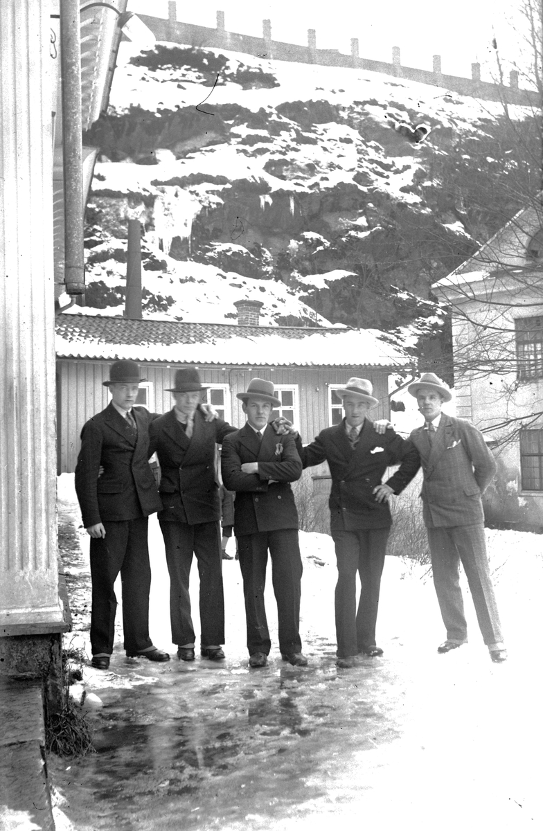 Fem män står framför Storkvarn, ett lågt trähus vid Dunkehallaån i Jönköping, området brukar kallas Busahål.