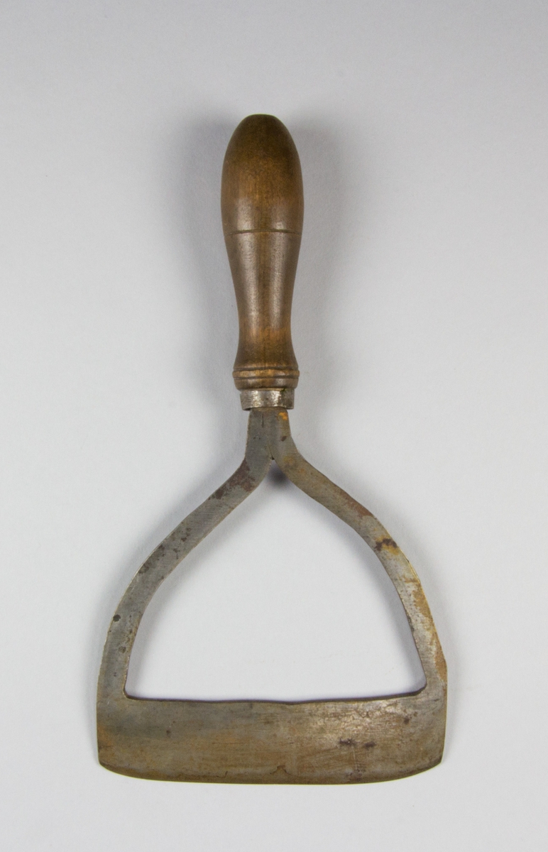 Hackkniv av stål och trä. Svarvat handtag av trä och bygelformat knivblad monterat i handtaget med hjälp av en ring av järn.