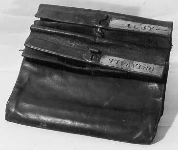 Lösväska i läder med bärrem och låsinrättning. Två fack med inskrift utskurna i mässingsplåtar: Alby respektive Östavall. Varje fack är låsbart separat.
