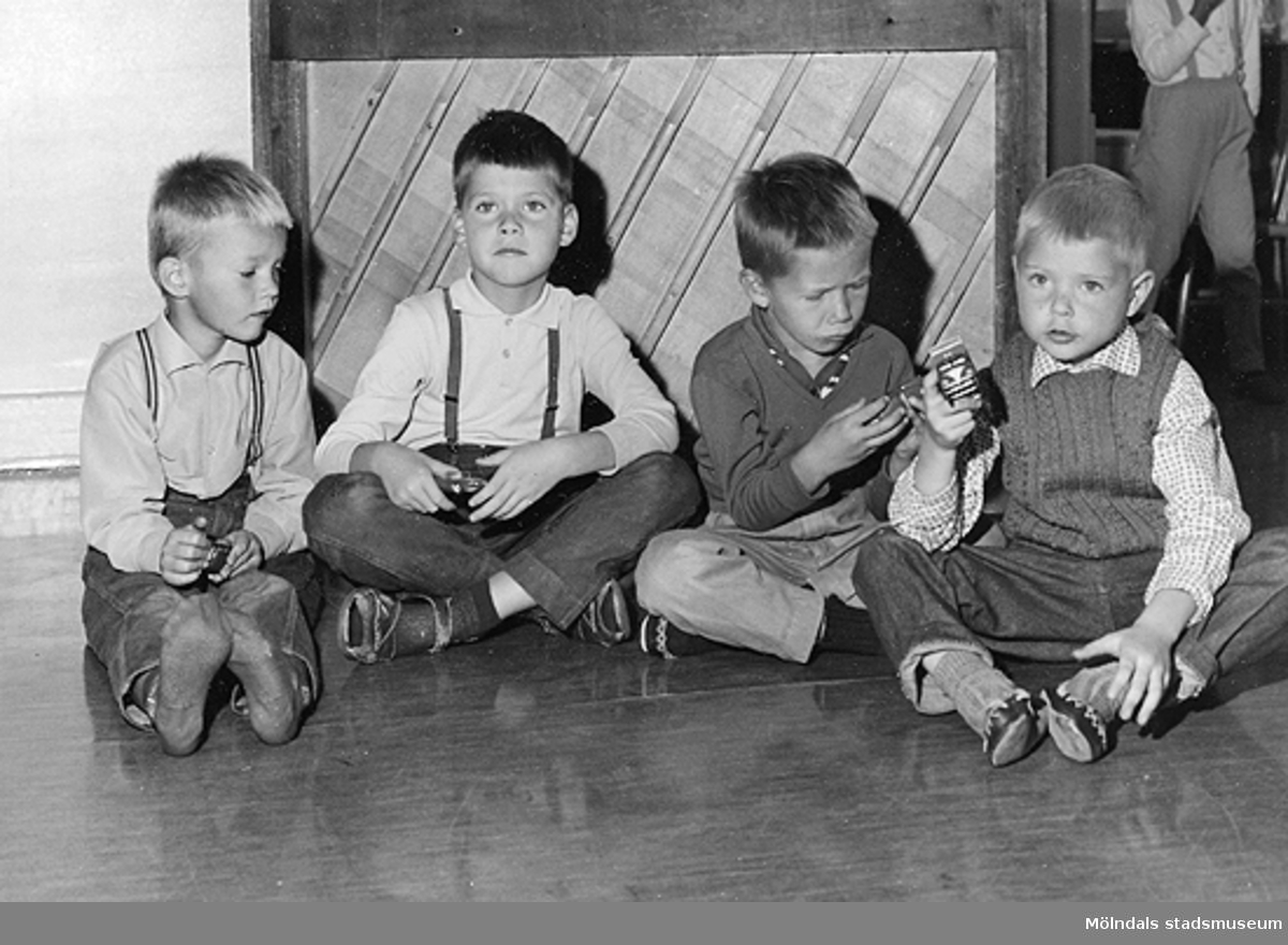 Fyra pojkar som sitter på golvet vid Holtermanska daghemmet 1953.