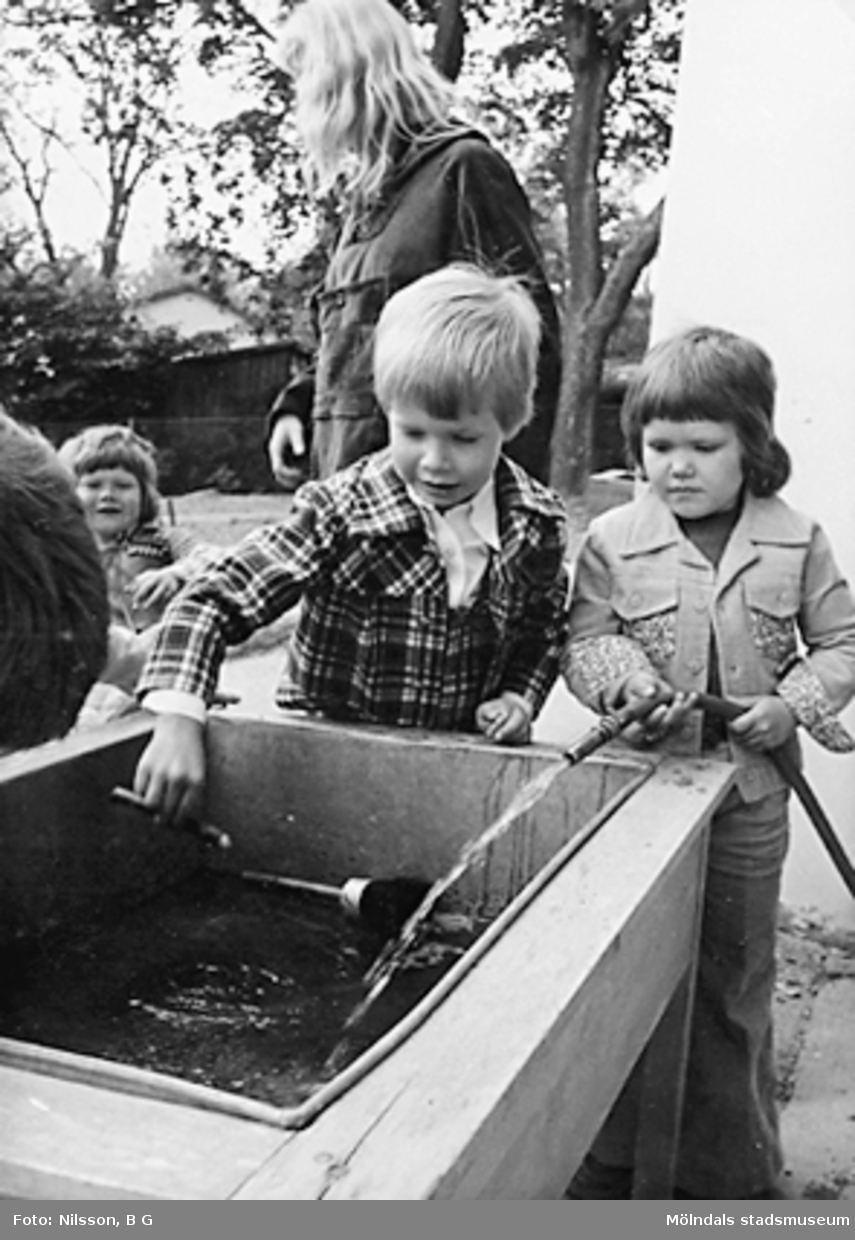 Barn som fyller en behållare med vatten. Holtermanska daghemmet juni 1974.