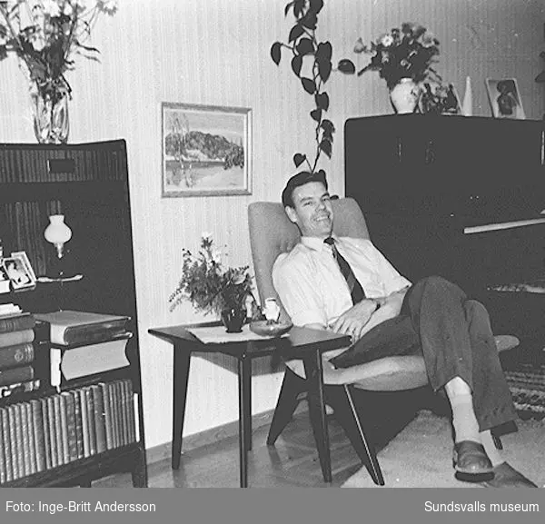 Göran Andersson i familjens vardagsrum, en tvårummare på Sveavägen 33, Sundsvall. Fåtöljen, bordet och bokhyllan inköptes från firman "Heminrednings AB Sven Staaf", Sundsvall, när familjen satte bo 1954.