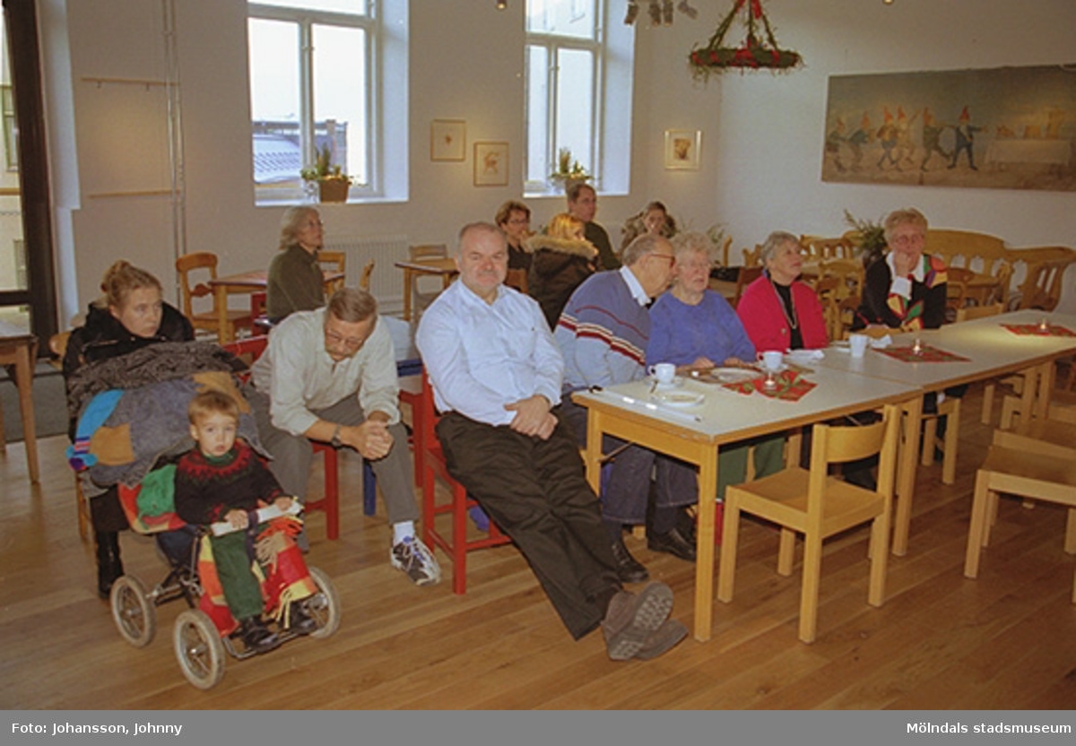 Publik sitter i Forscaféet och lyssnar till Lommebôs spelmanslag som spelar på Mölndals museum 2002-12-22.
