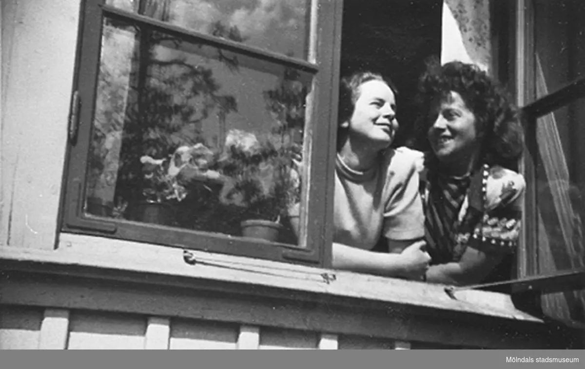 En lärare och bitr. föreståndare Margit Emilsson (gift Wannerberg -52) tittar ut genom fönstret på Krokslätts daghem, Dalhemsgatan 7 i Krokslätt år 1949.
