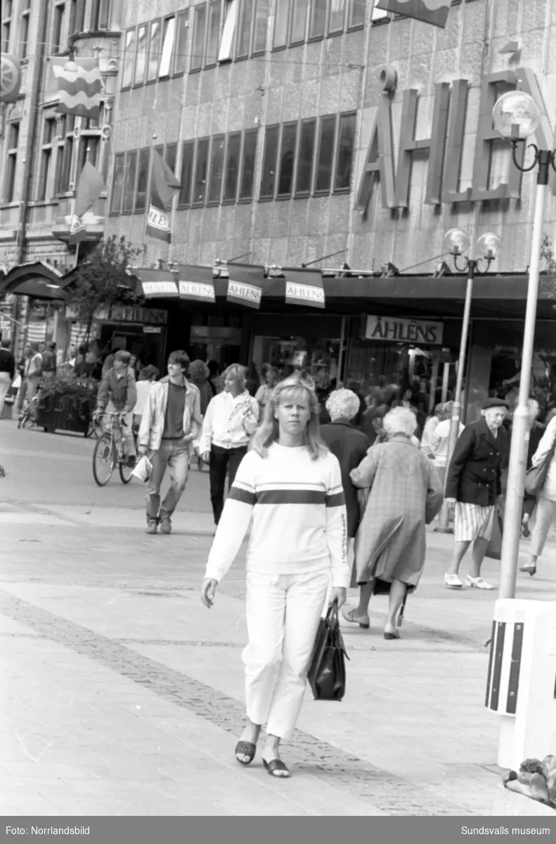 Mycket folk rör sig i centrala Sundsvall en augustidag 1984. Bland annat ett gäng killar som framför streetdance.