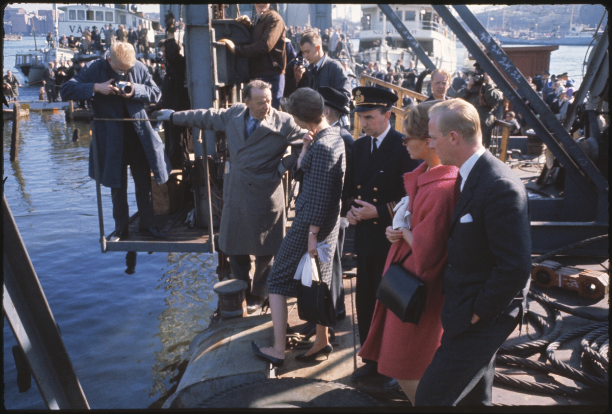Fotografer, journalister och Kommendör Edward Clason (längst till vänster) och prinsessorna Margaretha och Birgitta ser Vasa bryta vattenytan på bärgningsdagen.