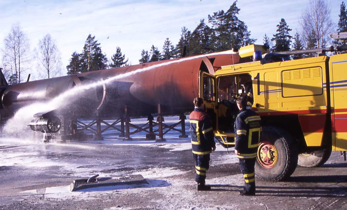 En gul brannbil fra Gardermoen Flyplass , OSL. Sett fra venstre, brannøvelse pågår.