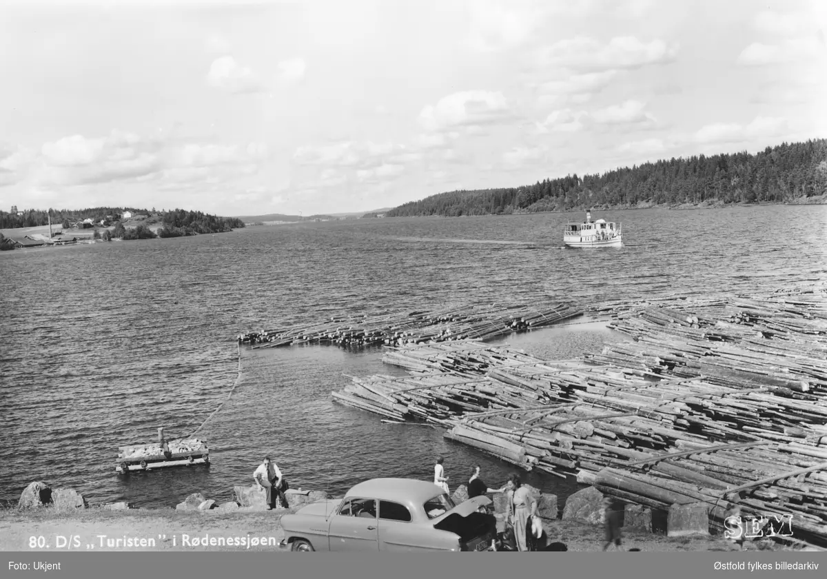 Parti fra Rødenessjøen i Ørje, prospektkort fra 1950-tallet.

Båten Turisten er på vei mot Ørje sluser som ligger utenfor bildet til høyre. 
Opel Rekord 1953-54 modell parkert helt i forgrunnen.