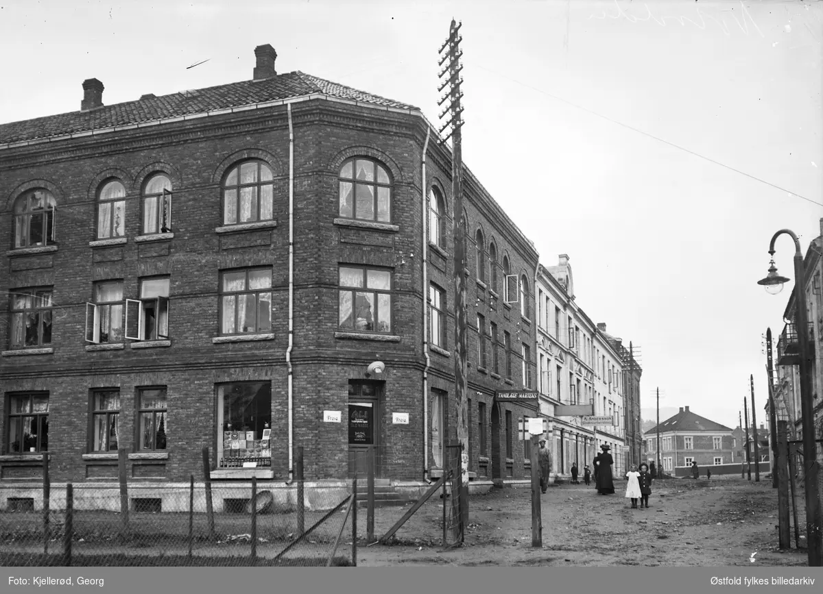 Notodden 1910.
bygningen i front er ant Victoria hotell, og  bygningen lengst «inne» i bildet er Heglandgården, og da er ant  Bjørnstjerne Bjørnsonsgate vi ser.
Skilt for tannlege Martens, og A. Andersson Blomsterforretning.