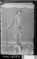 Portrett av stående mann med hund og gevær.