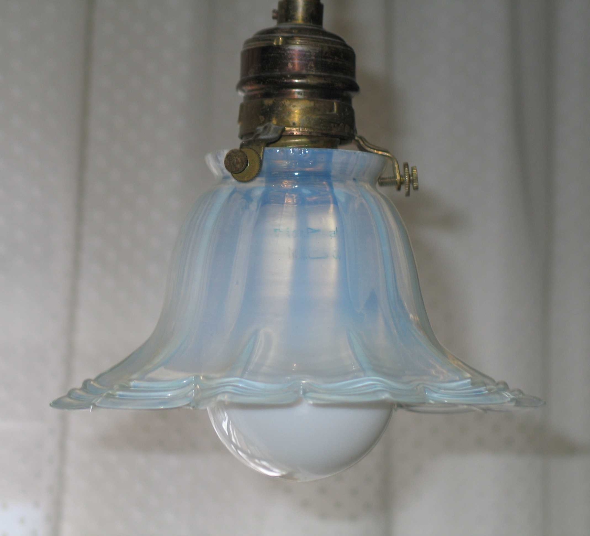 Liten taklampe med klokkeformet glasskjerm. Skjermen er gjennomsiktig melkehvit med blåskjer.