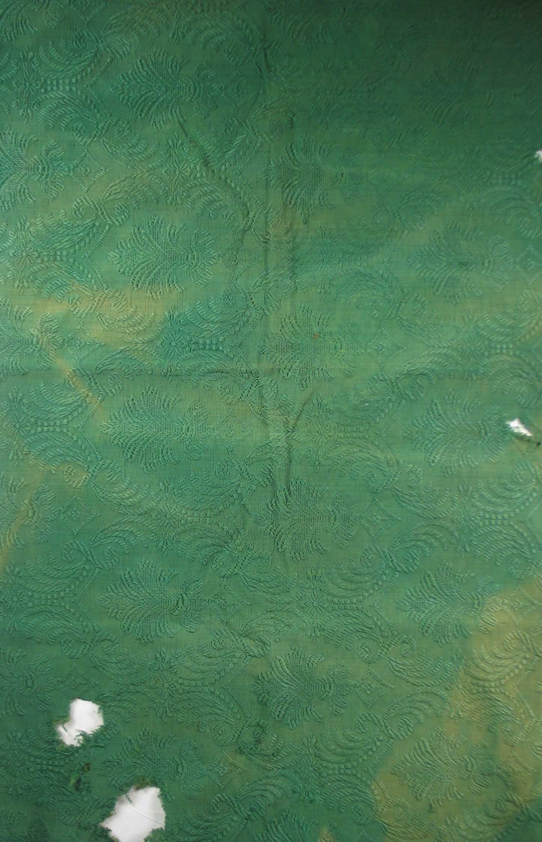 Mørk grønt jacquardvevd portierestoff . Mønstring ved flottering av mercerisert bomull på ripsbunn.
Motiv: Palmett i oval form, omgitt av bladverk; stilisert. Mønsterets rapport er høyden 37 cm, i bredden 20 cm.