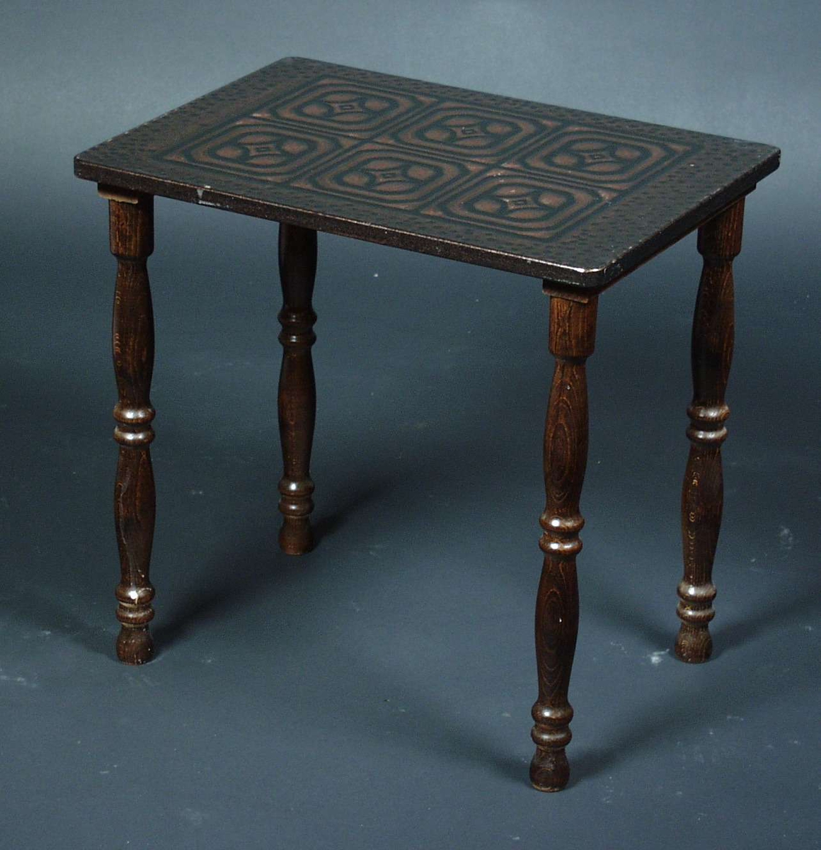 Settbord i bøk med dreide ben.
Bordplaten er i mønstret metall i form av stjerner.