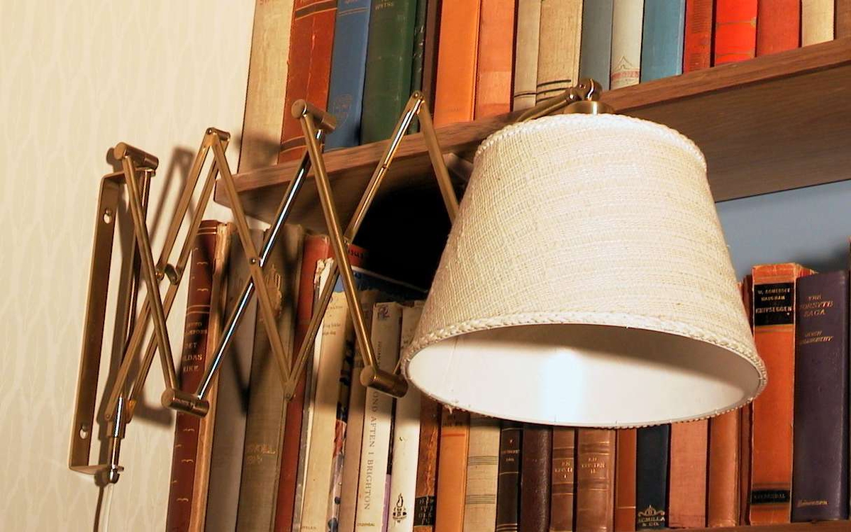 Utrekkbar lampe med beige skjerm i plast.