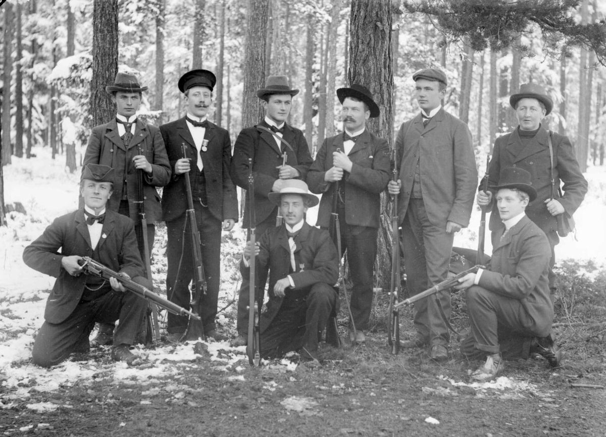 G. O. Hovis gruppe fra skytterfest. 11.10.1903. Gruppebilde i skog og snø, menn med geværer.
