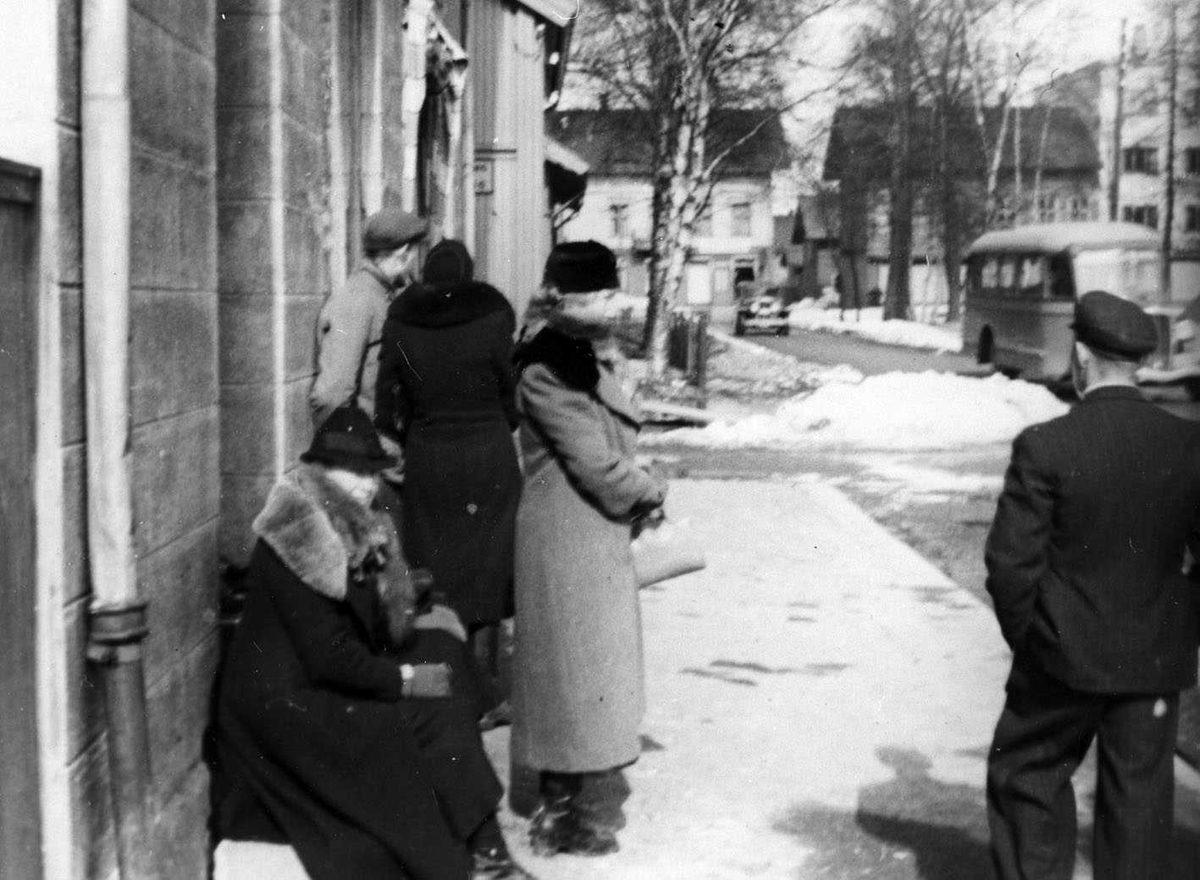Lillestrøm 9. april 1940. Mennesker som venter på evakueringsbuss (til Toten)
Sittende Marie Erikstad, stående Marta Erikstad, med ryggen til Gerda Erikstad, Arne Erikstad