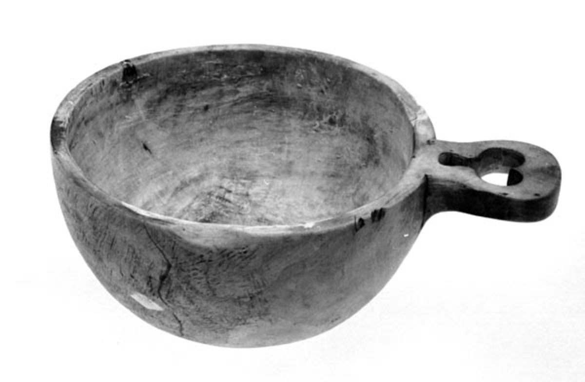 Materialet er bjørk. Koppen er kjøpt av Aasheims kone ca. 1920 på auksjon. O B står antagelig for Ole Bjørns (Landsjøåsen). Brukt til å røre ut munkrøre i. 
