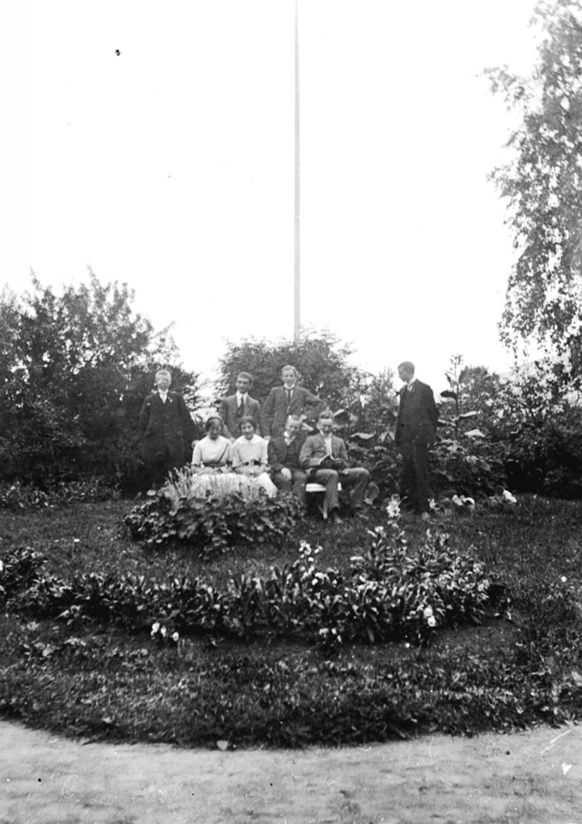 Gruppe personer foran flaggstang i hagen hos familien Løken på Granerud gård, Brumunddal.