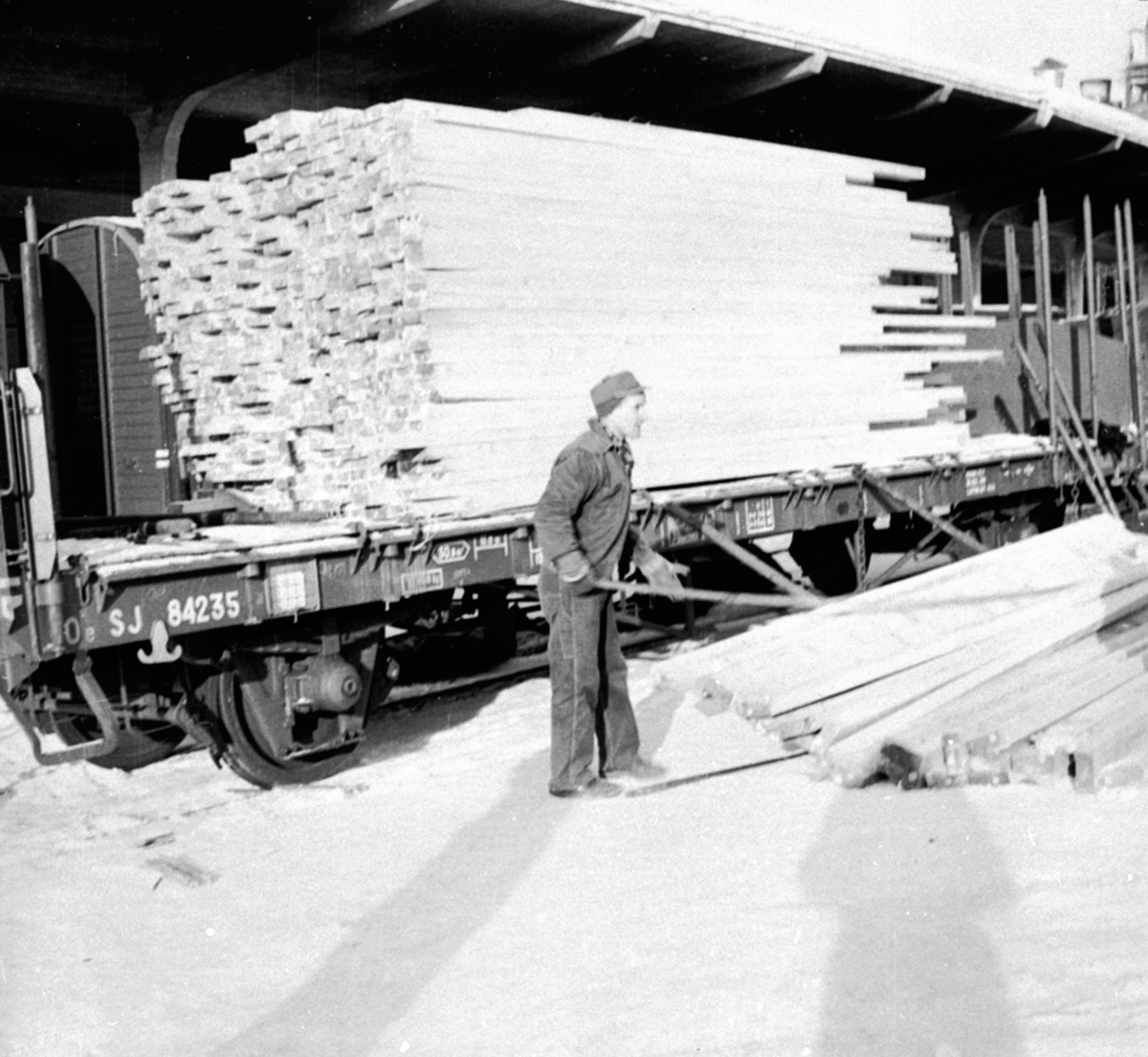 Mann laster, materialer, plank på jernbanevogn, Berger Langmoen A/S, Brumunddal,.