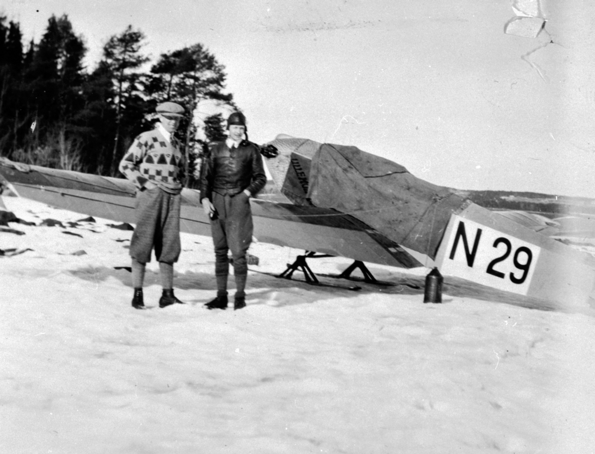 Ole Fladeby og Leif Lier foran fly (N-29) med ski utenfor Odden/Framnes, Helgøya. N-29 var en Klemm L. 20B-1 cn:72. Denne registreringen hadde flyet mellom mars 1929 til mars 1933. Leif Lier eide dette flyet i 1929.