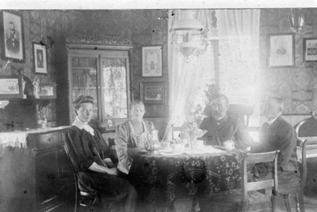 Interiør, stue i lærerboligen på Gaalaas skole (Gålås), Furnes, Ringsaker. Fra venstre er Magnhild Mæland f.1885, Anne Spikdalen Mæland f.13.1.1856, O.A.Mæland f.1849, Olaf Mæland f.1887.