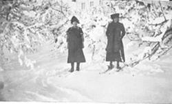 2 DAMER PÅ SKI I KJOLE OG KÅPE, HAGE, VINTER