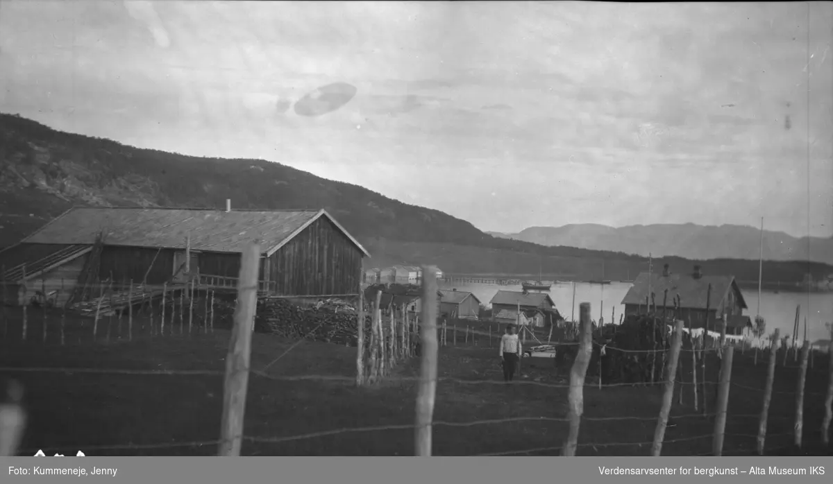 Inngjerdet gårdstun med bygninger og fjord i bakgrunnen.1919