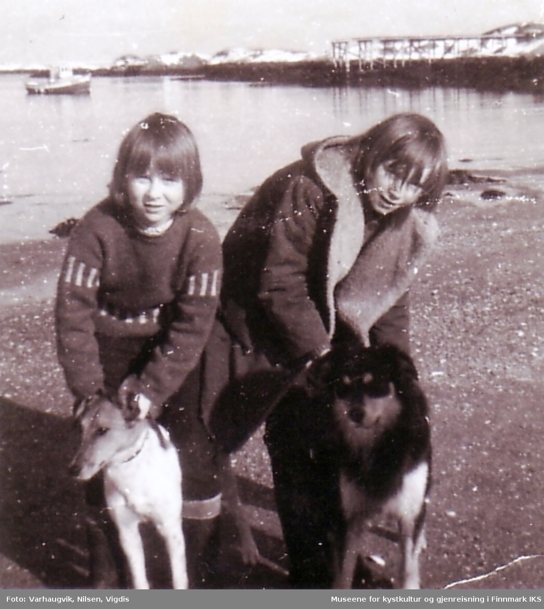 To piker med hunder på kirkesanda, Ingøy.