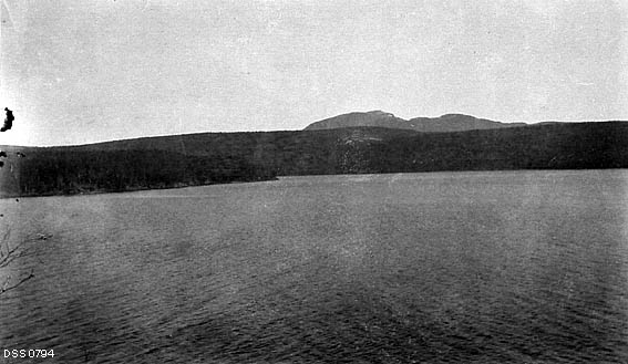 Oversiktsfotografi over Unkervatn med de skogkledde åsene i Tjolmen statsskog på motsatt side. 
