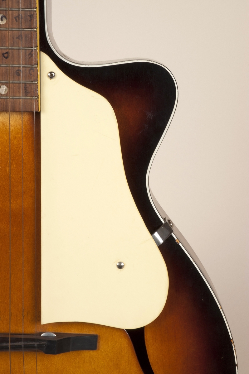 Gitar med enkel cutaway og hul kropp (hollow body), lakkert i Sunburst-finish.