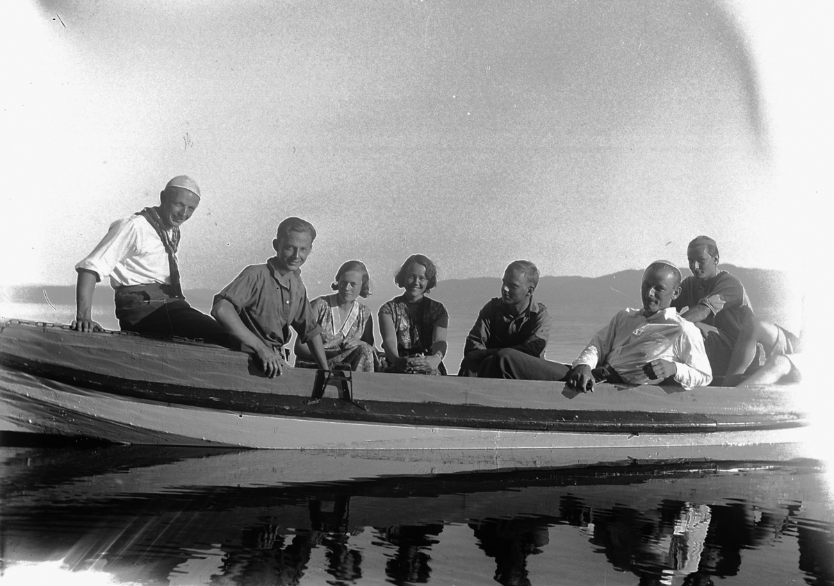 Gruppe ungdom i båt på vannet utenfor Kvalstua, Helgøya.